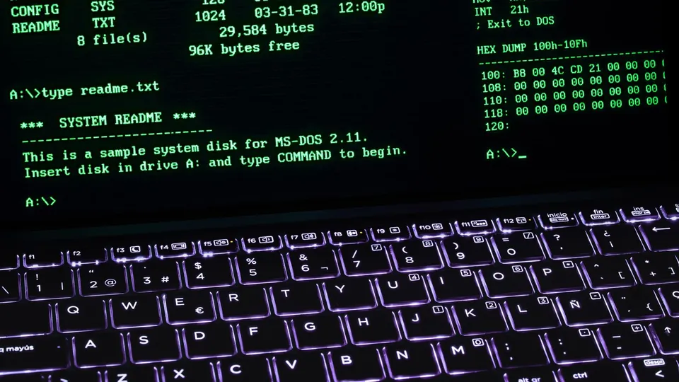 Laptop showing a retro MS-DOS style terminal with an illuminated keyboard